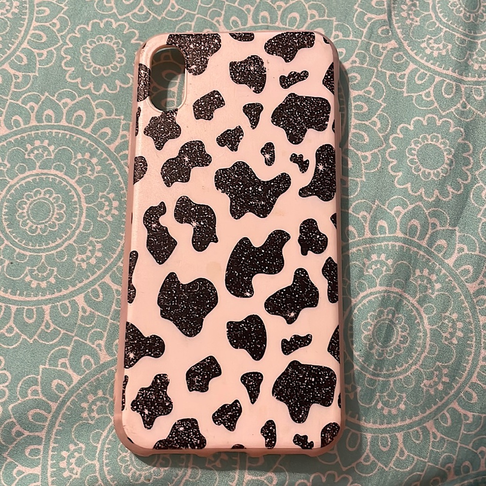 iPhone XS, pink sides, white background, sparkly black cow print.